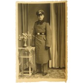 Foto de un soldado pionero alemán de cuerpo entero, con abrigo y gorra de visera